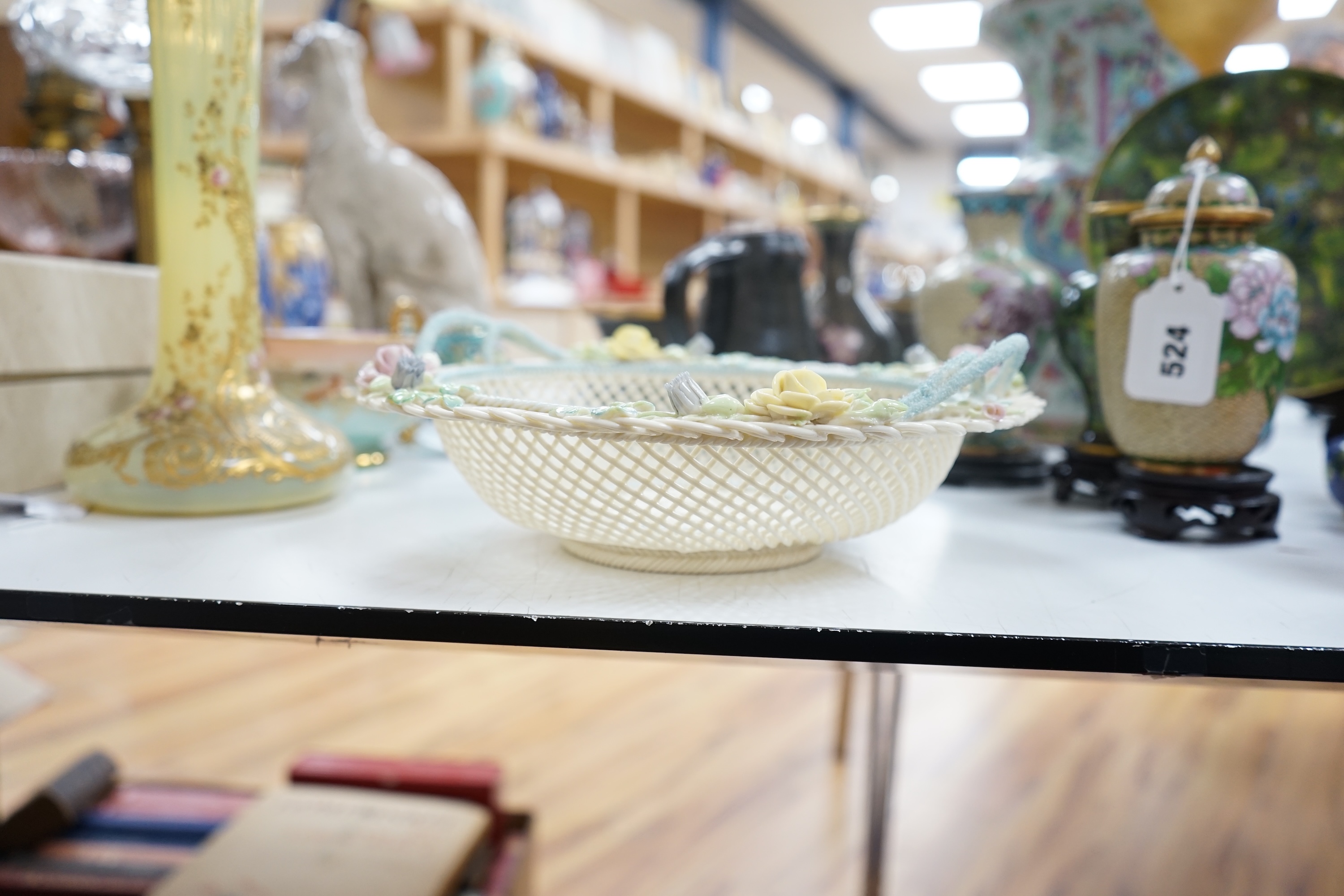 A boxed Belleek coloured basket, 28cm diameter. Condition - fair to good, some damage and wear to the box.